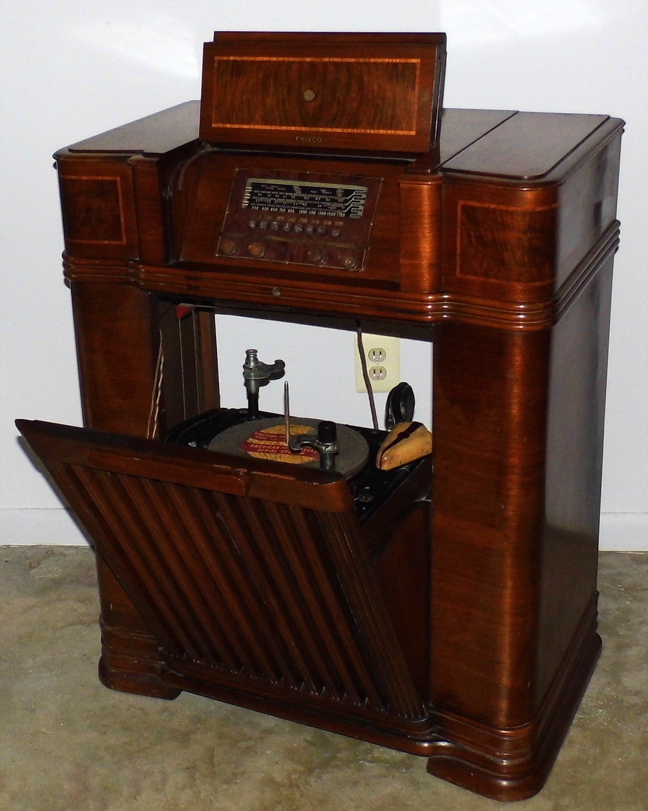 A 1940–1941 Philco radio and phonograph console with its lid open above the turntable and record-cutting head.